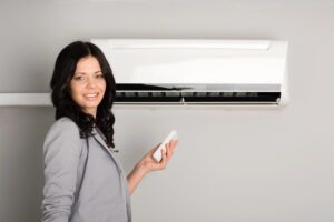 a woman in her home in calgary holding an ac remote